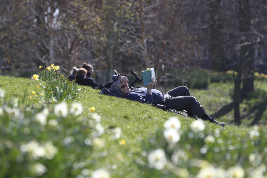 People enjoy the sunny weather in Sefton Park in Liverpool, England, Sunday April 4, 2021.  During current coronavirus restrictions people are allowed to meet up and exercise in the open air.