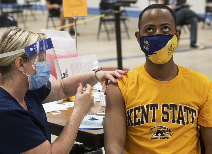 Kent State University student Marz Anderson gets his Johnson &amp; Johnson COVID-19 vaccination from Kent State nurse Beth Krul in Kent, Ohio, Thursday, April 8, 2021. U.S. colleges hoping for a return to normalcy next fall are weighing how far they should go in urging students to get the COVID-19 vaccine, including whether they should - or legally can - require it.