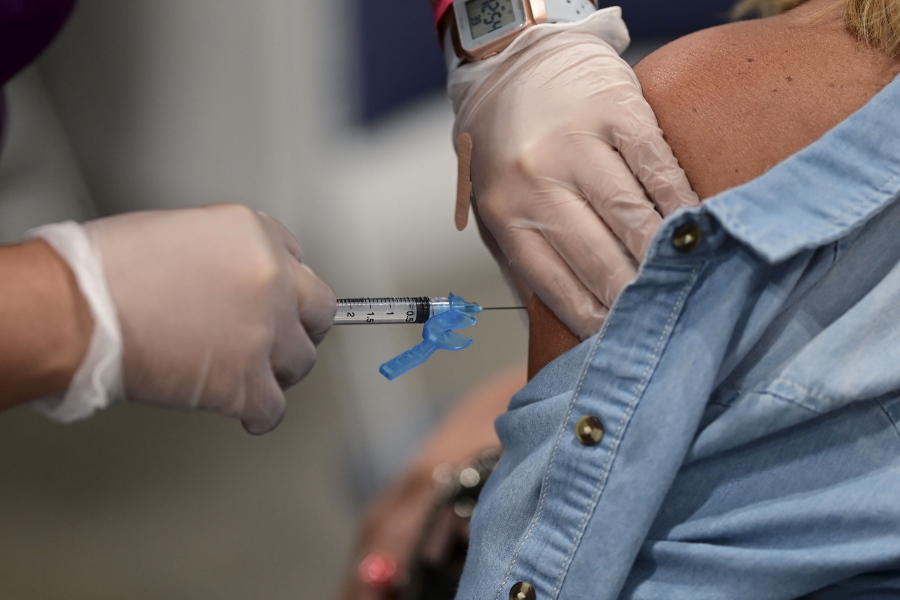 A health worker applies a Johnson and Johnson COVID-19 vaccine during a mass vaccination event carried out by the Department of Health and the Voces nonprofit organization, at the Miramar Convention Center in San Juan, Puerto Rico, Wednesday, March 31, 2021.