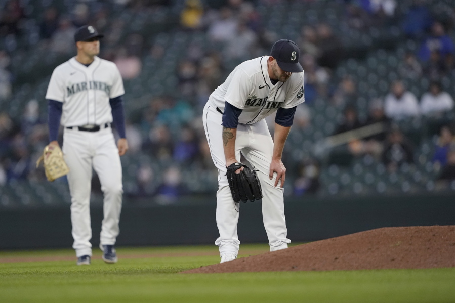 Seattle Mariners starting pitcher James Paxton, right, reacts near the mound after experiencing an injury during the second inning of a baseball game against the Chicago White Sox, Tuesday, April 6, 2021, in Seattle. Paxton left the game and the White Sox won 10-4. (AP Photo/Ted S.