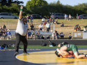 Washington Officials Association referee Lee Lofton calls two points for a takedown on Wednesday at Hudson's Bay High School. The dual meet between Woodland, Ridgefield and Hudson's Bay was believed by coaches to be among the first outdoor dual meets held in state history.