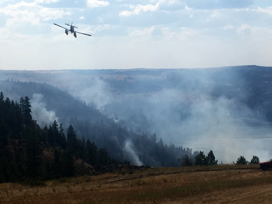 A Fire Boss plane - a fixed-wing aircraft used in wild land fire suppression - battles a wildfire in Eastern Washington in 2018.