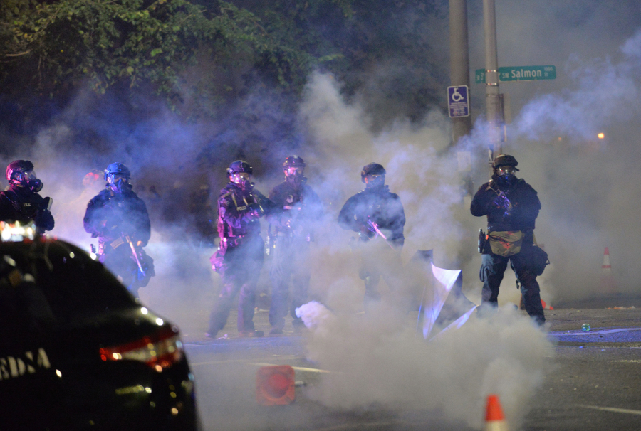 Security personnel stand in a cloud of tear gas in Portland, Oregon, early Sunday, July 26, 2020, as protests continued across the United States following the death of George Floyd.