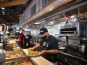 Ezekiel Gonzalez of Beaches Restaurant and Bar works during the lunchtime rush May 6.