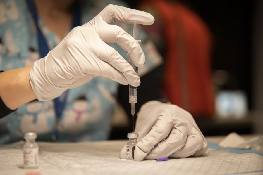 Kelli Newcom, R.N., preps vials of the Pfizer COVID-19 vaccine to be administered to teachers and educators at The Oregon Convention Center on January 27, 2021, in Portland.