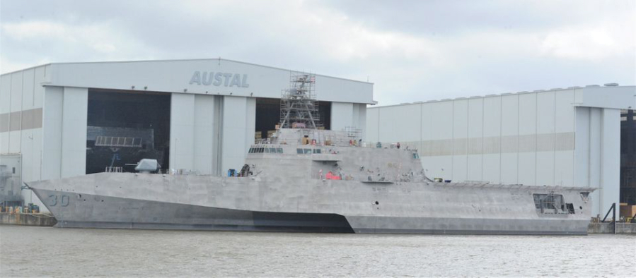 LCS-30, the future USS Canberra, is seen docked in front of the Austal USA facilities on the Mobile River where the company builds Littoral Combat Ships for the U.S. Navy.