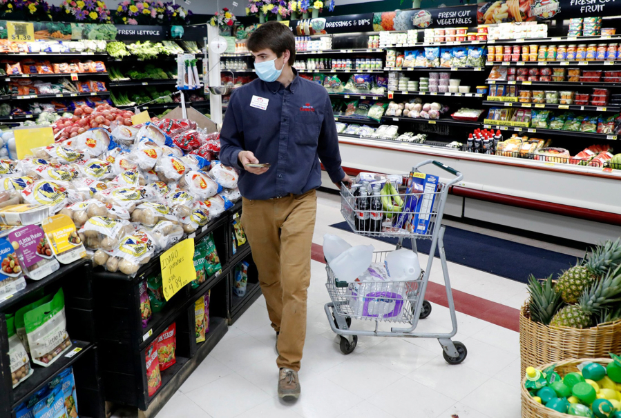 Johnny Grizzard, grocery manager at the Carlie C's IGA in Angier, N.C., fulfills an online order while working Tuesday, April 14, 2020.