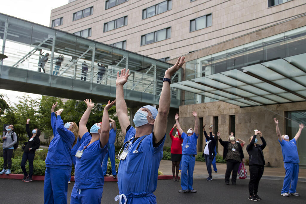 Dr. Pierre Provost, an anesthesiologist at Legacy Salmon Creek Medical Center, joins colleagues and hospital staff as they greet members of the Oregon Air National Guard as they fly two F-15 Eagles over the area on Friday morning, May 22, 2020. Amanda Cowan won a first place Society for Professional Journalists award for the photo.