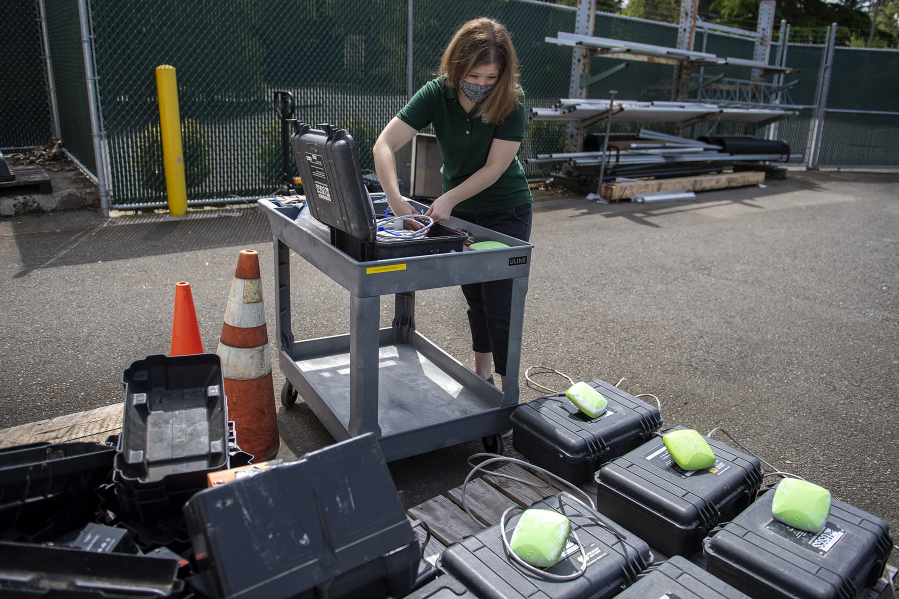 Geophysicist Rebecca Kramer charges batteries for high-precision GPS equipment at USGS Cascades Volcano Observatory in Vancouver late last month. Staff was packing up monitoring gear being shipped to be used in studies of the volcanic system at Yellowstone National Park.