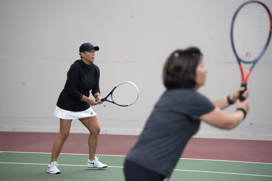 Jill Watson, left, who hosts a tennis tournament Alzheimer's fundraiser in the spring each year, joins Delena Palena as they take on opponents at Club Green Meadows in Vancouver.
