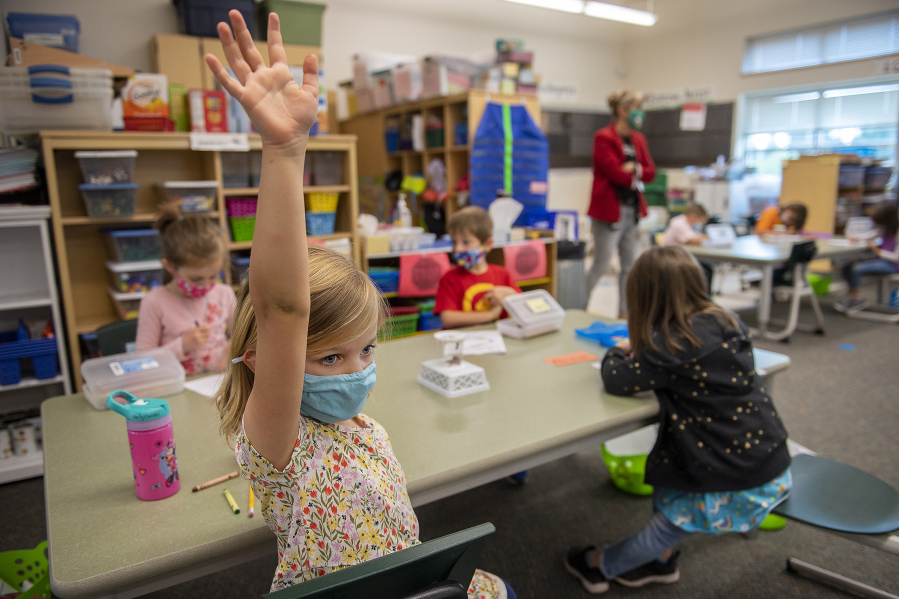 Kindergartner Emily Christel, foreground, joins classmates during in-person learning at Eisenhower Elementary School on Monday, the first day of expanded in-person instruction at Clark County's second-largest district.