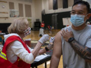 Medical Reserve Corps volunteer Ruth Gorley gives Vancouver resident Ryan Tydingco a Johnson & Johnson COVID-19 vaccine May 8 at Clark County Public Health's short-term vaccination pod at Woodland High School. After an early rush of people, the flow had slowed down by the late morning for the drop-in vaccination event.