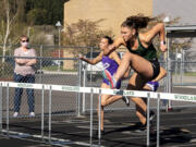 Woodland senior Lucy George clears a hurdle in the 100-meter hurdles at a 2A Greater St. Helens League track meet on  April 15 at Woodland High School. George, a Grand Canyon University track and field commit, hasn't lost an event this season - she has competed in the long jump, high jump, hurdles, javelin and shot put - and has a Division I collegiate spot locked up. But while others see athletic success, George struggles to find confidence in herself. She still battles with body image issues and grapples daily with overcoming an eating disorder that stemmed from a past coach telling her she needed to lose weight.