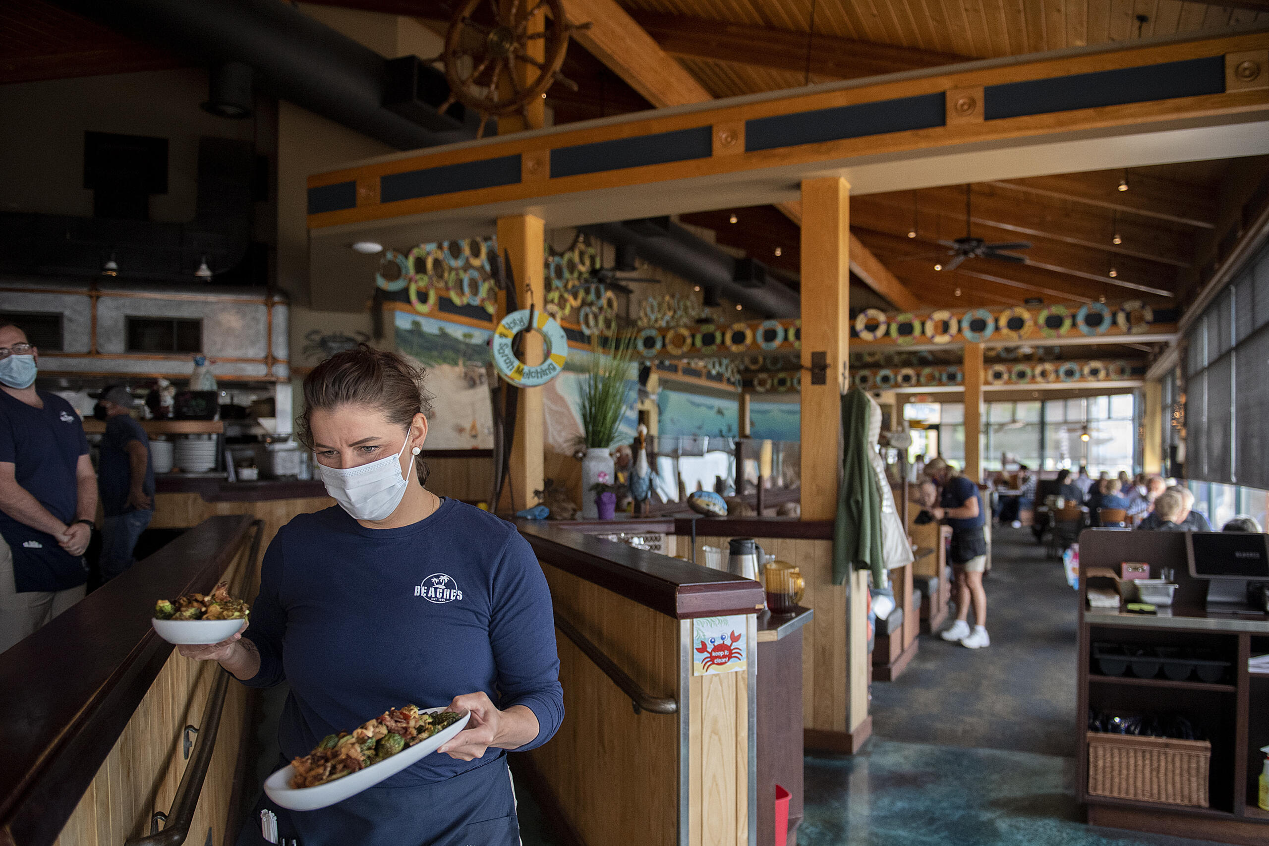 Chrissy Gibbins of Beaches restaurant brings out dishes to lunchtime customers on Thursday morning, May 6, 2021. Beaches, along with most restaurants in Vancouver, is having trouble filling open positions.