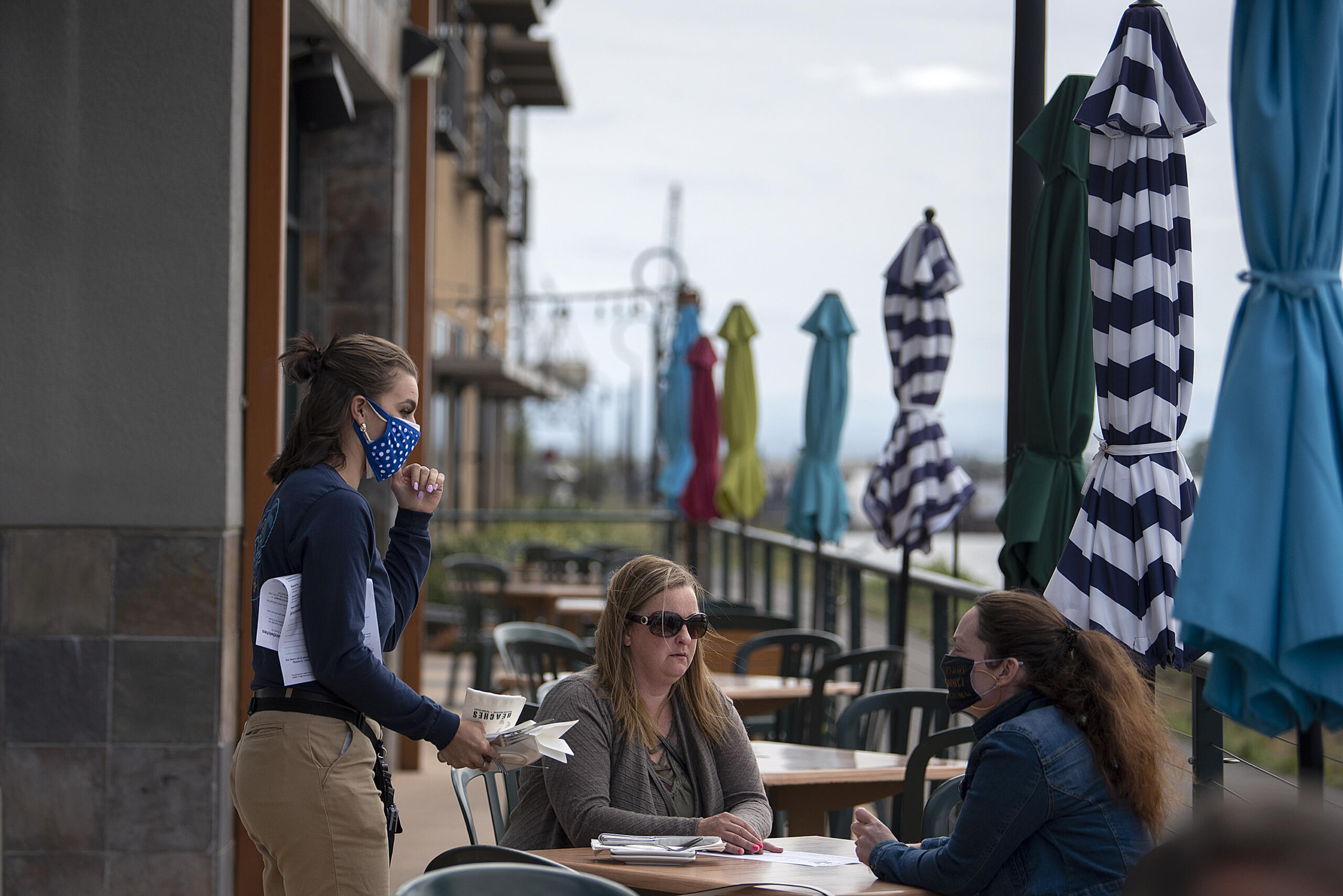 Mackenzie Samuelson, from left, of Beaches restaurant chats with customers Andrea Pelton and Maegan Davies while stopping by their table on Thursday morning, May 6, 2021.