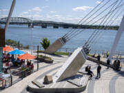 Visitors to The Waterfront Vancouver enjoy the sunny weather with a stroll or a lunch outside Tuesday afternoon. Clark County has fewer restrictions on activities than the rest of the Portland metro area, and local restaurants have seen an influx of customers from Oregon as a result.