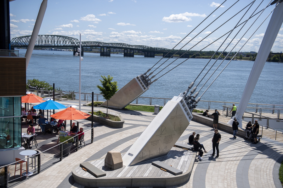 Visitors to The Waterfront Vancouver enjoy the sunny weather with a stroll or a lunch outside Tuesday afternoon. Clark County has fewer restrictions on activities than the rest of the Portland metro area, and local restaurants have seen an influx of customers from Oregon as a result.