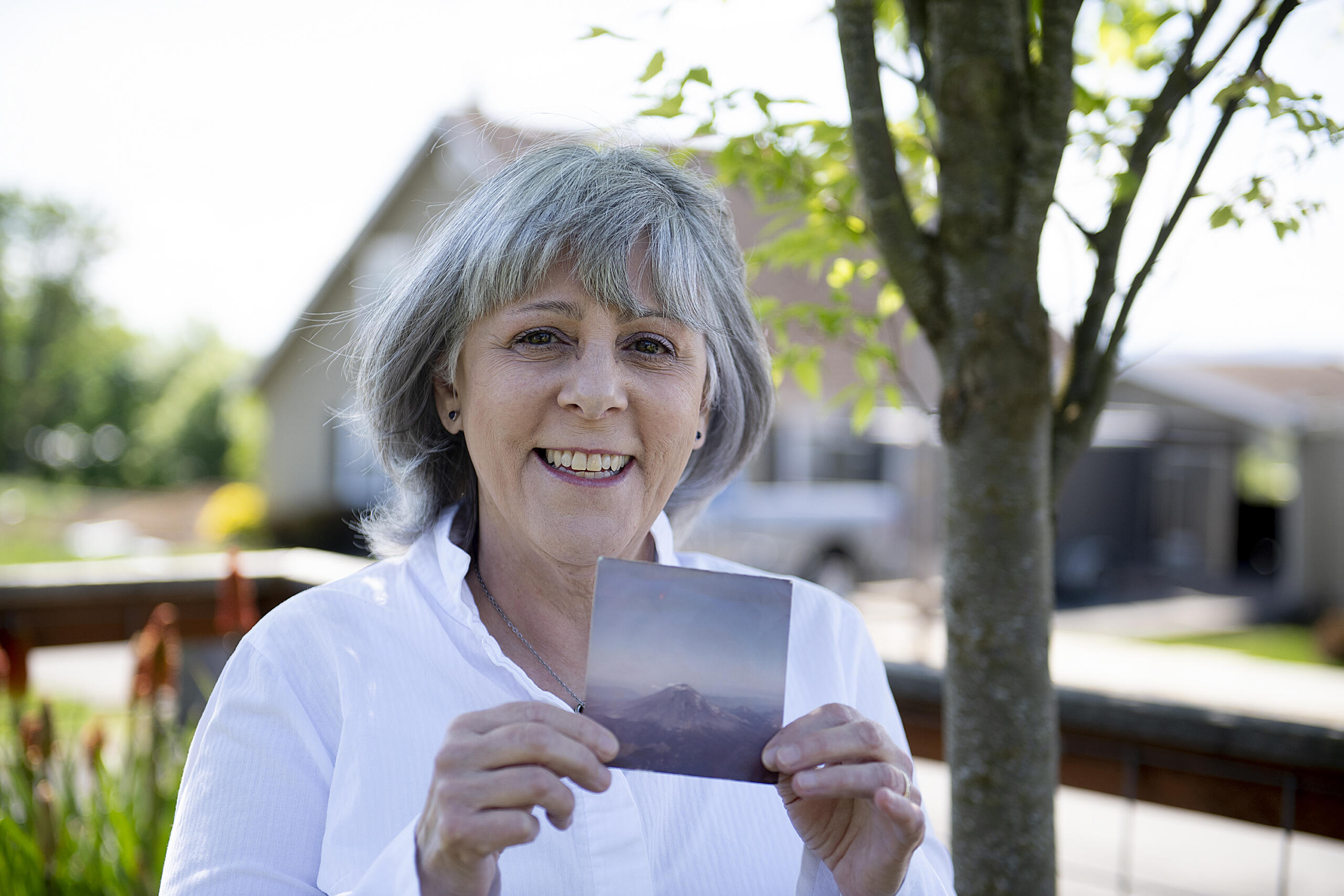 Jaquie Cole of Ridgefield pauses for a portrait with a photo she took of Mount St. Helens in 1980 on Monday afternoon, May 10, 2021. Cole and her friend flew in a small plane over Mount St. Helens on the afternoon of May 17, 1980, less than 24 hours before the big eruption.
