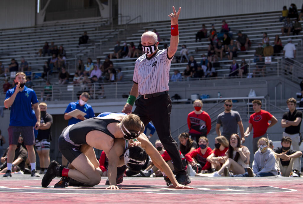 Longtime referee Dick Ford signals two points for a takedown as Camas’ Porter Craig wrestles Mountain View’s Noah Messman at a 4A/3A Greater St. Helens League meet on Saturday, May 15, 2021, at Doc Harris Stadium in Camas.
