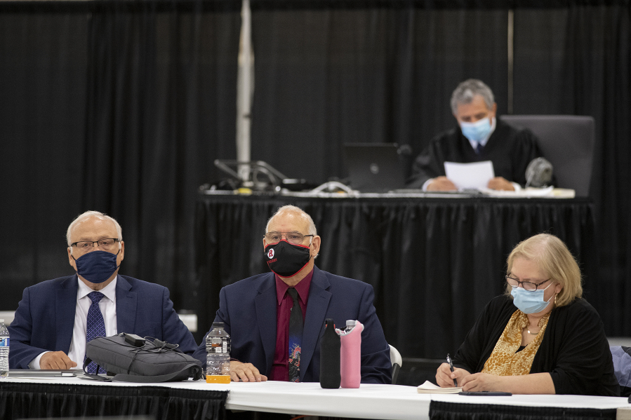 Plaintiffs Don Benton, foreground from left, Christopher Clifford and Susan Rice join Superior Court Judge Gregory Gonzales, background top, as they gather for closing arguments in their lawsuit against the county Monday afternoon at the Clark County Event Center at the Fairgrounds.