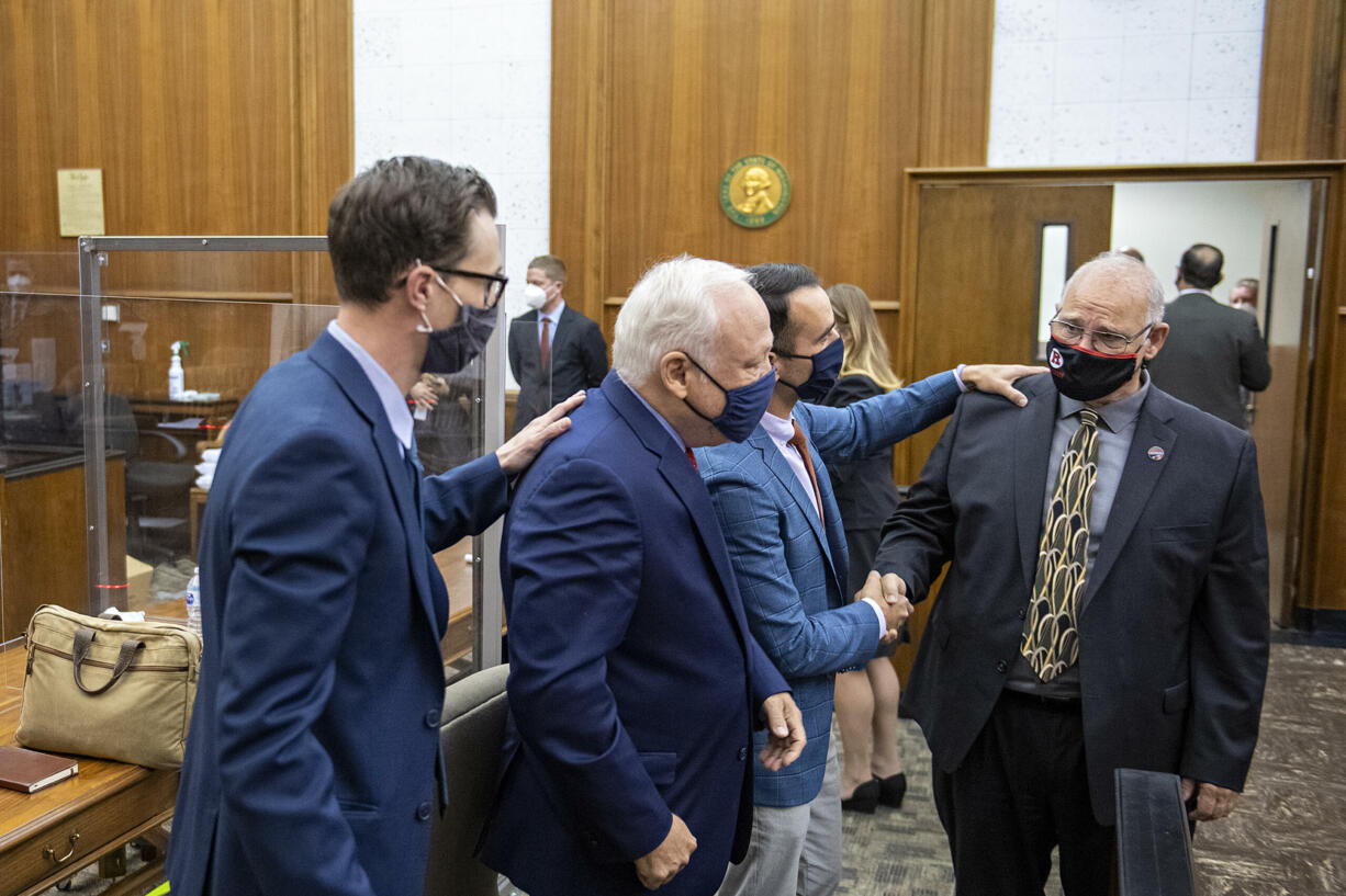 Attorney Mark Conrad. from left, congratulates Don Benton as fellow attorney Evan Bariault supports Christopher Clifford after the jury ruled in their favor at the conclusion the lawsuit trial at the Clark County Courthouse on Thursday morning, May 20, 2021.
