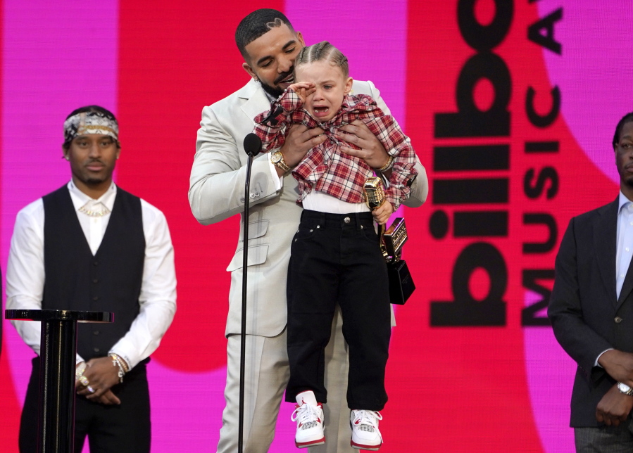 Drake carries his son Adonis Graham as he accepts the artist of the decade award at the Billboard Music Awards on Sunday, May 23, 2021, at the Microsoft Theater in Los Angeles.