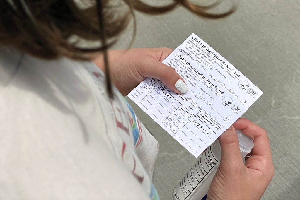 Jane Ellen Norman, 12, holds vaccination cards for her and her 14-year-old brother Owen outside Mercedes-Benz Stadium in Atlanta on Tuesday, May 11, 2021. The two were vaccinated Tuesday morning, after U.S. regulators expanded use of Pfizer's COVID-19 shot to those as young as 12.