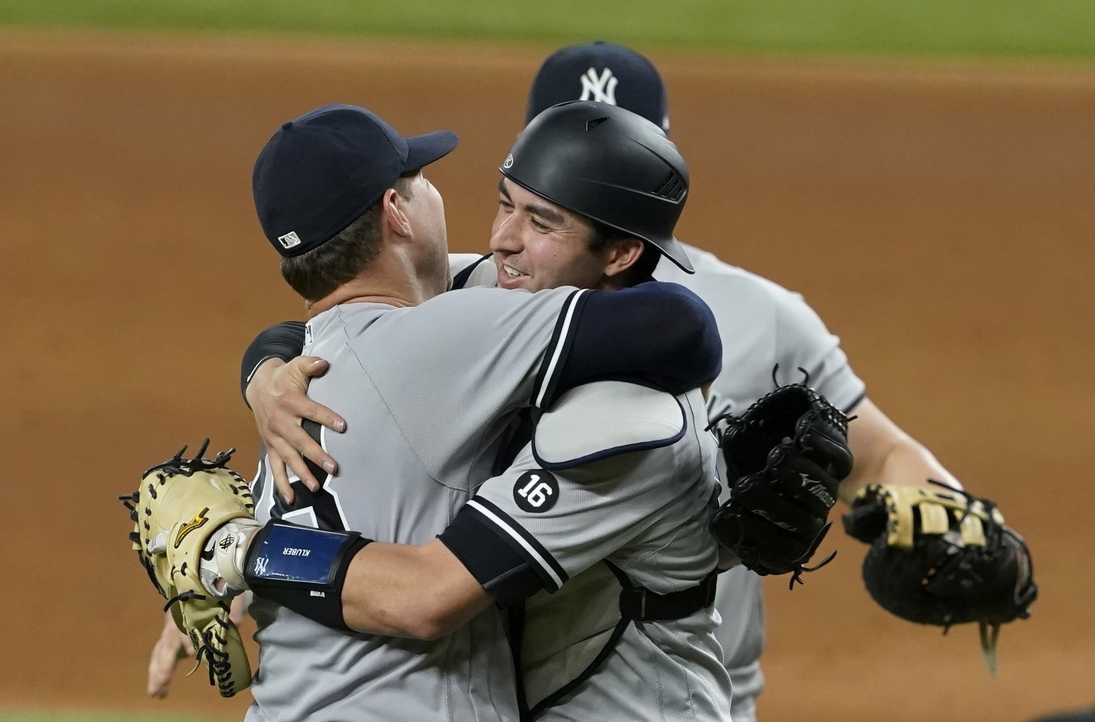 New York Yankees starting pitcher Corey Kluber, catcher Kyle Higashioka, right, and first baseman Luke Voit, rear, celebrate after Kluber threw a no-hitter against the Texas Rangers in a baseball game in Arlington, Texas, Wednesday, May 19, 2021.
