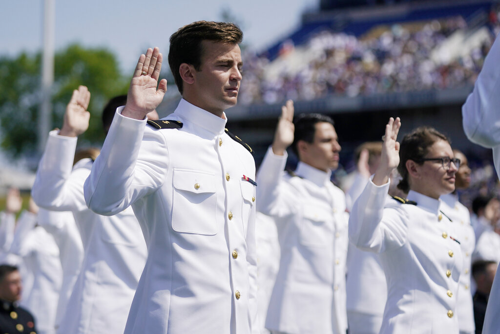 Graduating U.S. Naval Academy midshipmen raise their right hands as they are commissioned at the graduation and commission ceremony at the U.S. Naval Academy in Annapolis, Md., Friday, May 28, 2021.