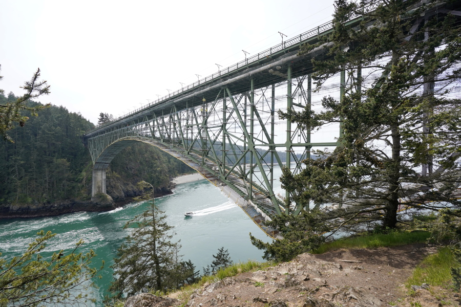 The Deception Pass Bridge, nearly 1,000-feet long and about 180-feet above the waters below, is covered in scaffolding as work to replace corroded steel and paint the structure continues Thursday, April 29, 2021, in Deception Pass, Wash. Raising state taxes to improve roads and bridges is one of the few things many Republican and Democratic lawmakers have agreed on in recent years. Those efforts have slowed to a crawl this year, even as lawmakers acknowledge a widening gap between needed work and the money to pay for it.