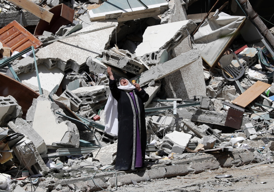 A woman reacts while standing near the rubble of a building that was destroyed by an Israeli airstrike on Saturday that housed The Associated Press, broadcaster Al-Jazeera and other media outlets, in Gaza City, Sunday, May 16, 2021.