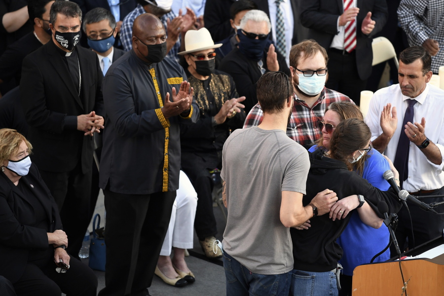 Family members of shooting victim Timothy Romo embrace during a vigil at City Hall in San Jose, Calif., Thursday, May 27, 2021, in honor of the multiple people killed when a gunman opened fire at a rail yard the day before.