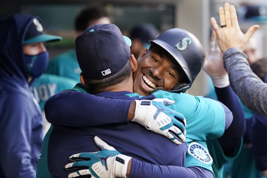 Seattle Mariners' Kyle Lewis is embraced by a teammate after his two-run home run against the Texas Rangers during the third inning of a baseball game Friday, May 28, 2021, in Seattle.