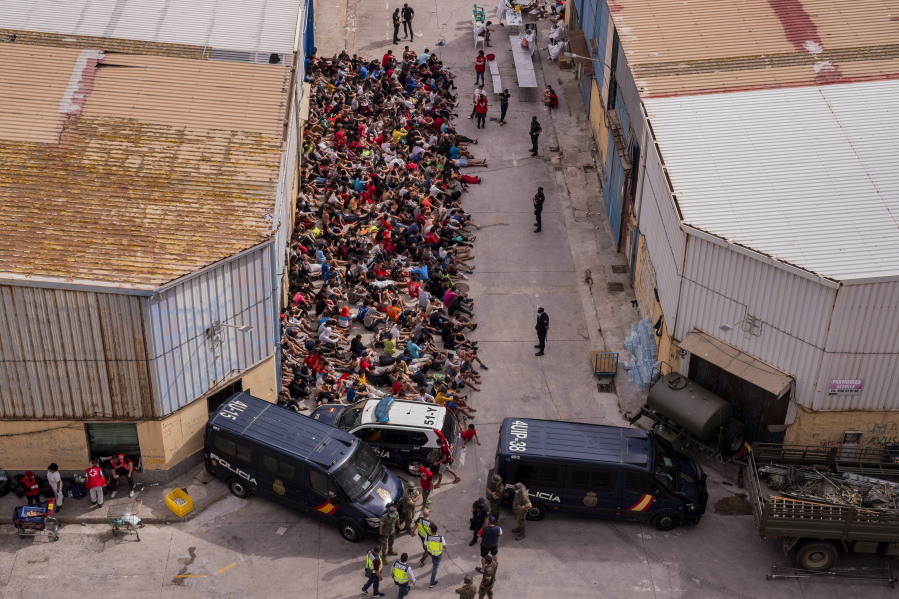 Unaccompanied minors who crossed into Spain are gathered outside a warehouse used as temporary shelter as they wait to be tested for COVID-19 at the Spanish enclave of Ceuta, near the border of Morocco and Spain, Wednesday, May 19, 2021. Social services for the small city perched on an outcropping in the Mediterranean buckled under the strain after more than 8,000 people crossed into Spanish territory during the previous two days.