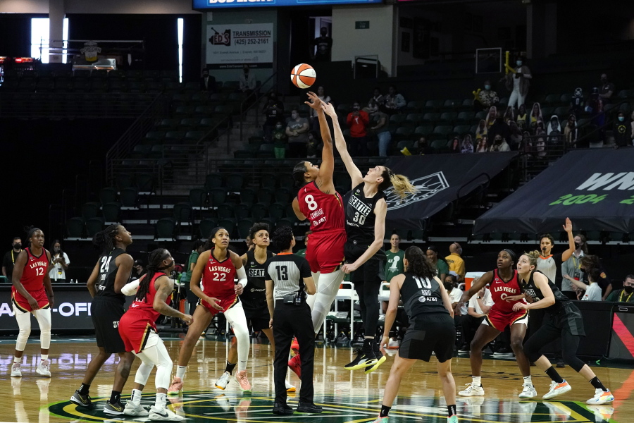 Las Vegas Aces' Liz Cambage (8) tips-off against Seattle Storm's Breanna Stewart to start the first half of a WNBA basketball game and their season Saturday, May 15, 2021, in Everett, Wash.