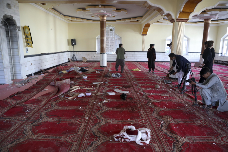 Afghan journalist take photos and film inside a mosque after a bomb explosion in Shakar Dara district of Kabul, Afghanistan, Friday, May 14, 2021. A bomb ripped through a mosque in northern Kabul during Friday prayers killing 12 worshippers, Afghan police said.