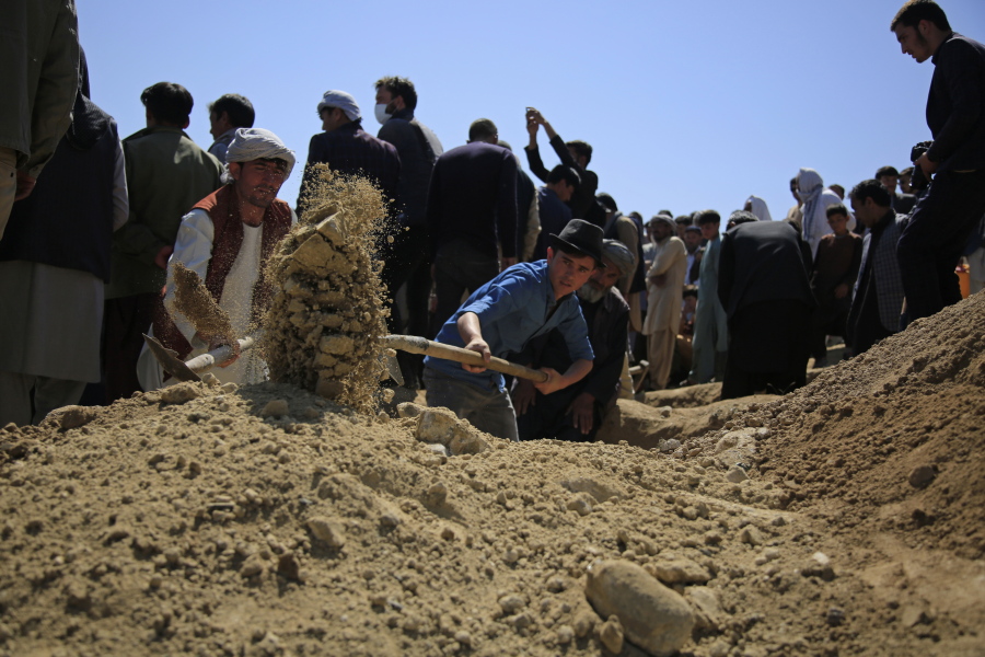 Afghan men bury a victim of deadly bombings on Saturday near a school, at a cemetery west of Kabul, Afghanistan, Sunday, May 9, 2021. The Interior Ministry said Sunday the death toll in the horrific bombing at the entrance to a girls' school in the Afghan capital has soared to some 50 people, many of them pupils between 11 and 15 years old, and the number of wounded in Saturday's attack has also climbed to more than 100.