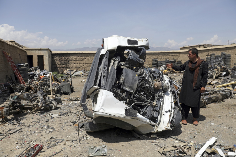 An Afghan man looks at a damaged vehicles in Baba Mir's scrapyard outside Bagram Air Base, northwest of the capital Kabul, Afghanistan, Monday, May 3, 2021. As US troops pack up to leave Afghanistan after nearly 20 years of war, it's trashing tons of equipment and selling it as scrap to local dealers. Among Afghans it is causing anger that the mountain of supplies and equipment was trashed before being sold to them.