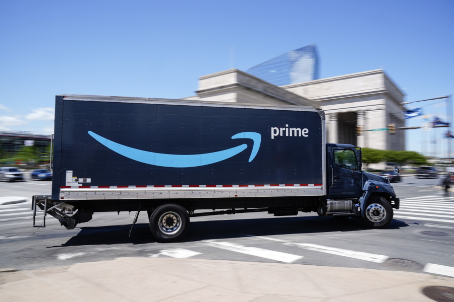 An Amazon truck drives in in Philadelphia, Friday, April 30, 2021.  Amazon is seeking to hire 75,000 people in a tight job market and is offering bonuses to attract workers, including $100 for new hires who are already vaccinated for COVID-19.