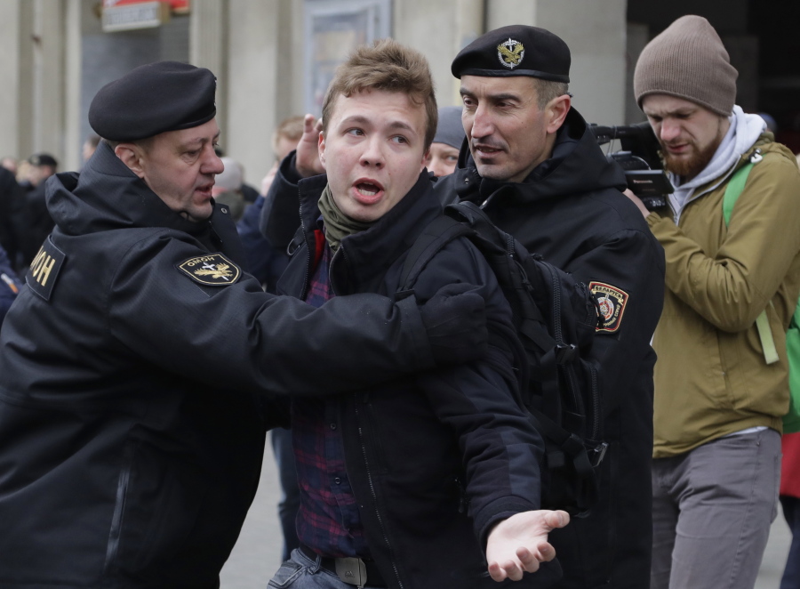 FILE - In this Sunday, March 26, 2017 file photo, Belarus police detain journalist Raman Pratasevich, center, in Minsk, Belarus. Raman Pratasevich, a founder of a messaging app channel that has been a key information conduit for opponents of Belarus' authoritarian president, has been arrested after an airliner in which he was riding was diverted to Belarus because of a bomb threat. The presidential press service said President Alexander Lukashenko personally ordered that a MiG-29 fighter jet accompany the Ryanair plane -- traveling from Athens, Greece, to Vilnius, Lithuania -- to the Minsk airport.