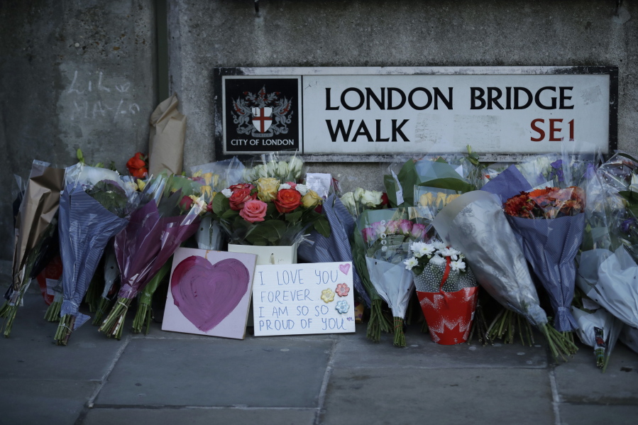 FILE - In this Monday, Dec. 2, 2019 file photo, tributes are placed by the southern end of London Bridge, three days after a man stabbed two people to death and injured three others before being shot dead by police, in London.  A string of failures by British authorities played a part in allowing extremist Usman Khan, who had been jailed for terrorism offenses, kill two people in a knife attack in London, an inquest jury concluded Friday, May 28, 2021.