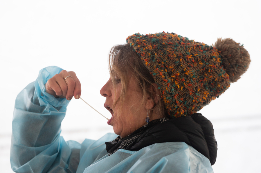 Kelly Lund swabs her mouth while demonstrating a self-administered oral COVID-19 test at the Tower Mall parking lot in January. The county closed that testing site on April 30 to focus on giving more COVID-19 vaccines at the site.