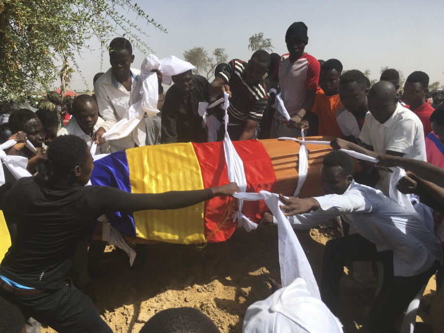 Mourners lower the coffin of one of the victims of protest who was killed this week during his funeral at a cemetery in N'Djamena, Chad, Saturday, May 1, 2021.