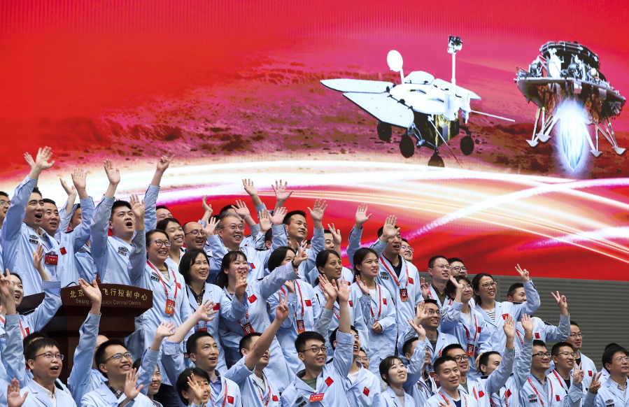 In this photo released by Xinhua News Agency, members at the Beijing Aerospace Control Center celebrate after China's Tianwen-1 probe successfully landed on Mars, at the center in Beijing, Saturday, May 15, 2021. China landed a spacecraft on Mars for the first time on Saturday, a technically challenging feat more difficult than a moon landing, in the latest advance for its ambitious goals in space.