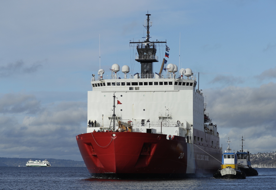 Tugboats help the U.S. Coast Guard Cutter Healy icebreaker into her homeport of Seattle in November 2018 as a Washington state ferry passes in the background following a four-month deployment to the Arctic Ocean.