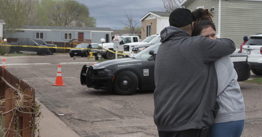 Family and friends of the victims who died in a shooting, comfort each down the street from the scene in Colorado Springs, Colo., on Sunday, May 9, 2021. The suspected shooter was the boyfriend of a female victim at the party attended by friends, family and children. He walked inside and opened fire before shooting himself, police said.