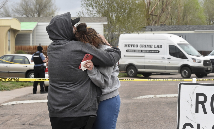 Freddy Marquez kisses the head of his wife, Nubia Marquez, near the scene where her mother and other family members were killed in a mass shooting early Sunday, May 9, 2021, in Colorado Springs, Colo.  The suspected shooter was the boyfriend of a female victim at the party attended by friends, family and children. He walked inside and opened fire before shooting himself, police said. Children at the attack weren't hurt and were placed with relatives.