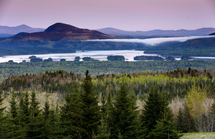 FILE - In this Tuesday, May 28, 2019, file photo is a view of Attean Pond near Jackman, Maine. Central Maine Power's controversial hydropower transmission corridor would be in the vicinity of this view from a scenic pullover. A 150-foot-wide swath of land would extend 53 miles from the Canadian border into Maine's north woods. (AP Photo/Robert F.