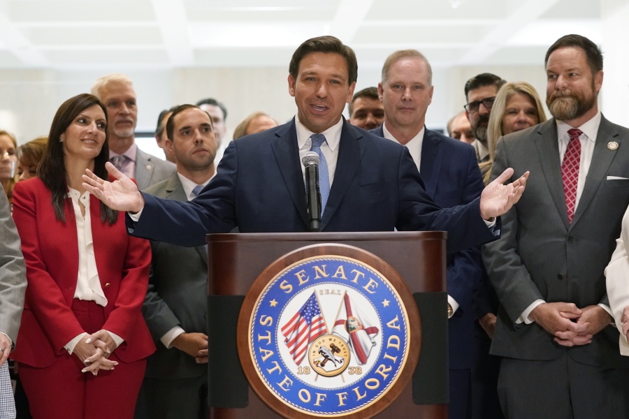 Surrounded by lawmakers, Florida Gov.Ron DeSantis speaks at the end of a legislative session, Friday, April 30, 2021, at the Capitol in Tallahassee, Fla.