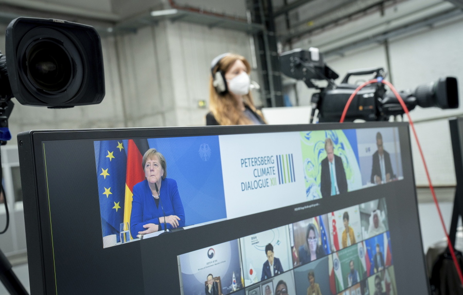 German Chancellor Angela Merkel (CDU) participates in the digital Petersberg Climate Dialogue, seen on the top left of a monitor, in Berlin, Germany, Thursday, May 6, 2021.